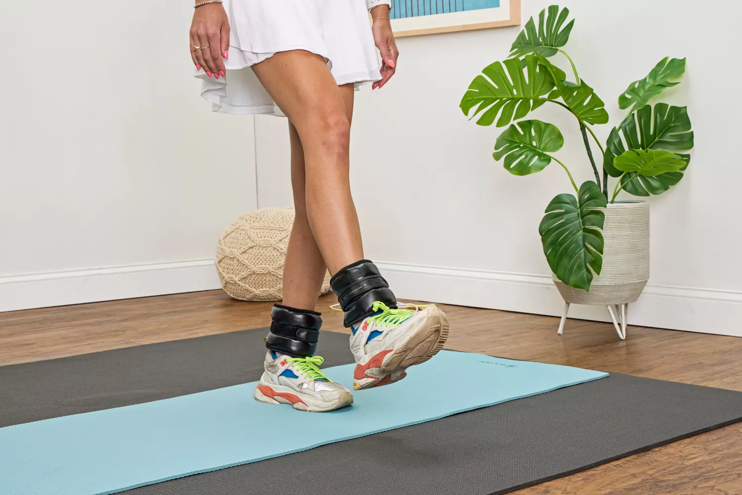 A person lifts their leg while wearing the Tracy Anderson UWRAPS Vegan Leather Ankle/Wrist Weights