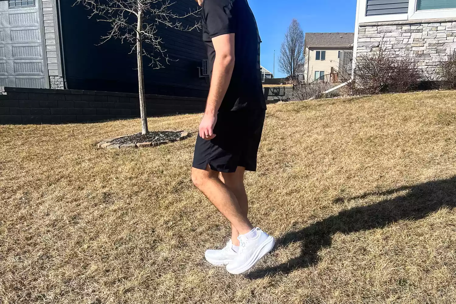 A person walking on grass while wearing the Asics Men's GEL-NIMBUS 27 sneakers