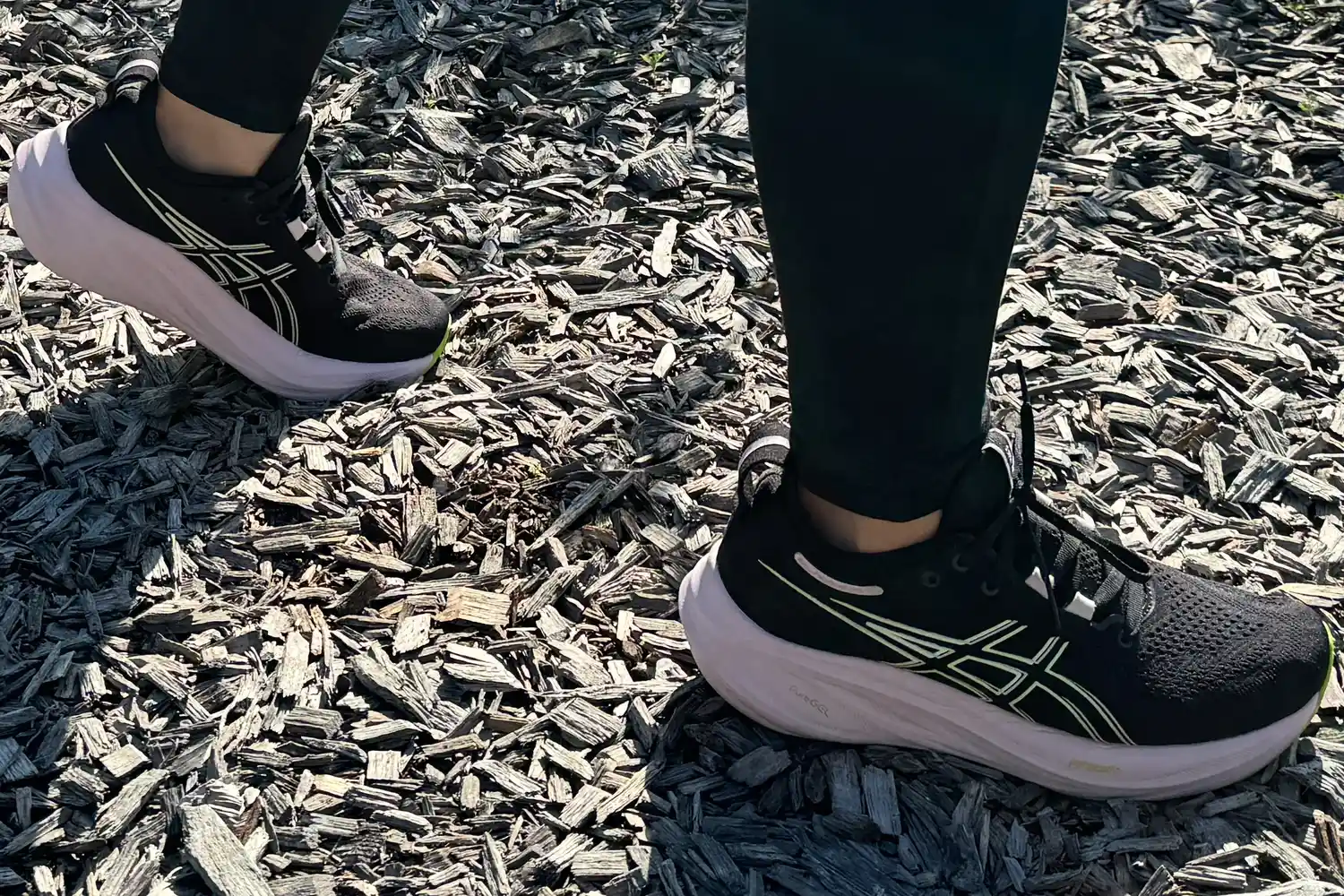 Woman walks on wooden piece by wearing Asics Women's Gel-Nimbus 26