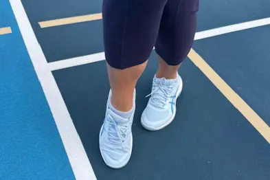 A person poses while wearing the Asics Women's Game FF Pickleball Shoes