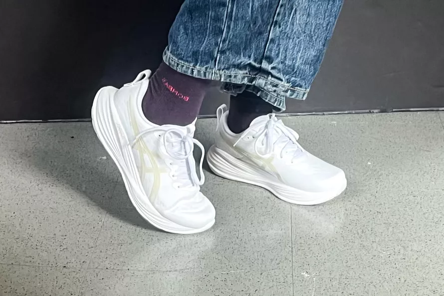 A person walks on tile while wearing the Asics Women's Gel-Cumulus 27 Running Shoes