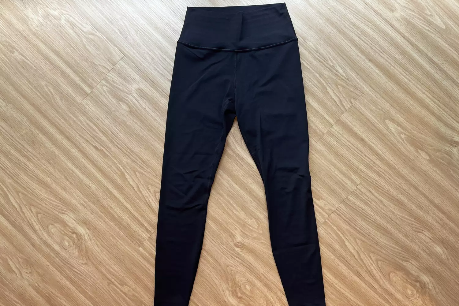 A pair of Athleta Transcend Tight on a wooden floor