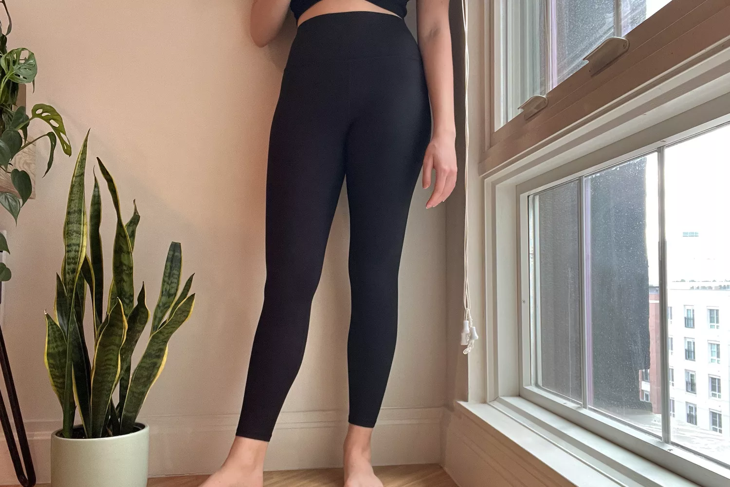 A person stands wearing the Athleta Transcend Tight