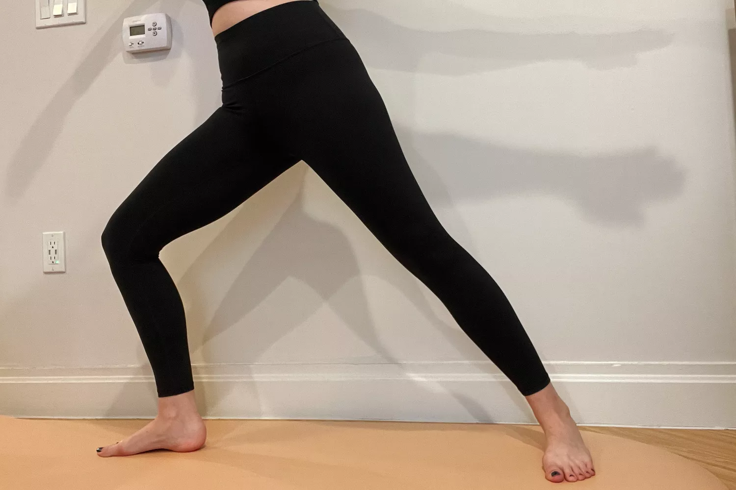 A person does warrior pose while wearing Athleta Transcend Tight