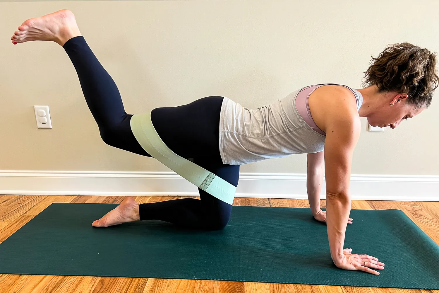 Person exercising on a yoga mat doing a resistance band exercise