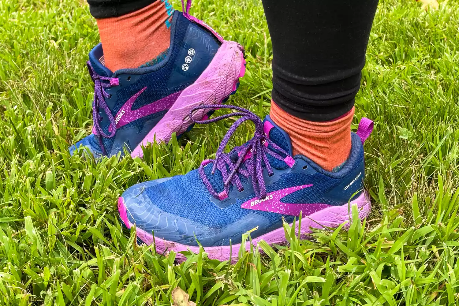A close-up of Brooks Cascadia 17 shoes worn in grass