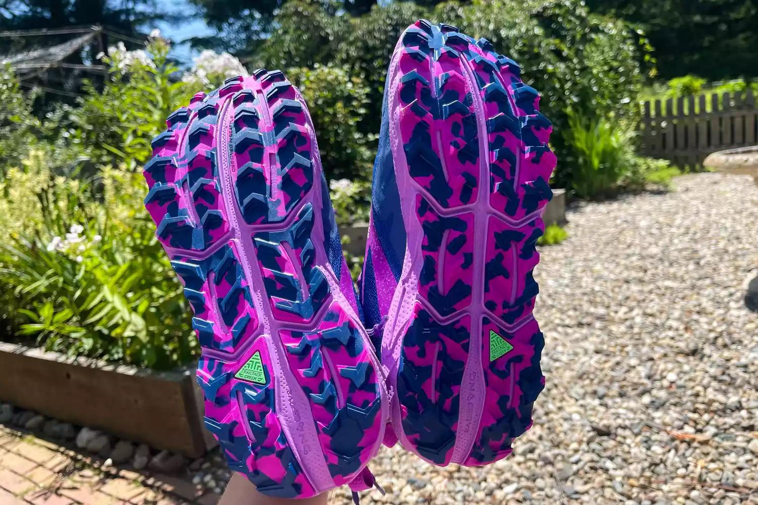 The bottoms of two Brooks Cascadia 17 shoes outdoors