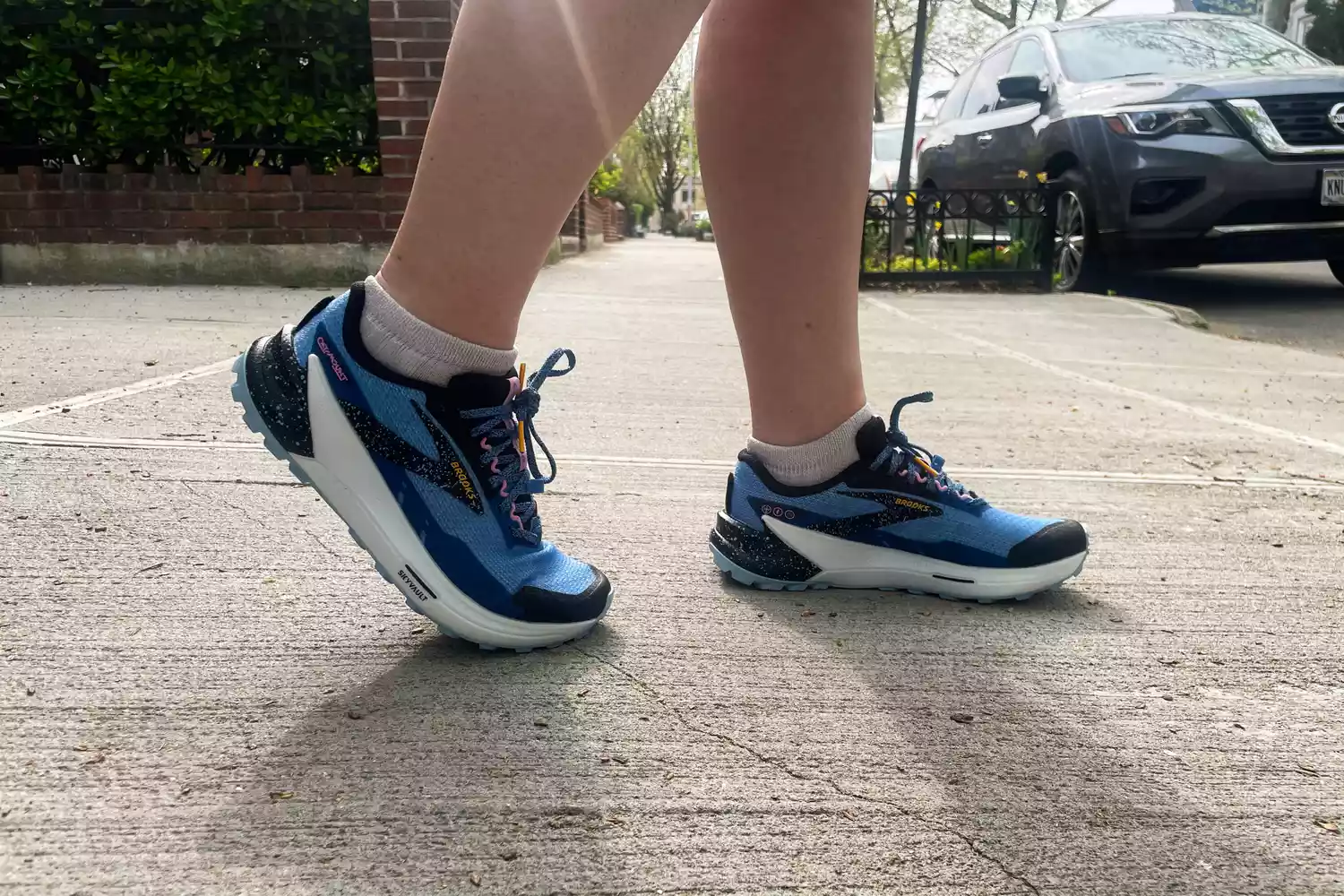 Two legs posed while wearing Brooks Catamount 2 Trail Running Shoes