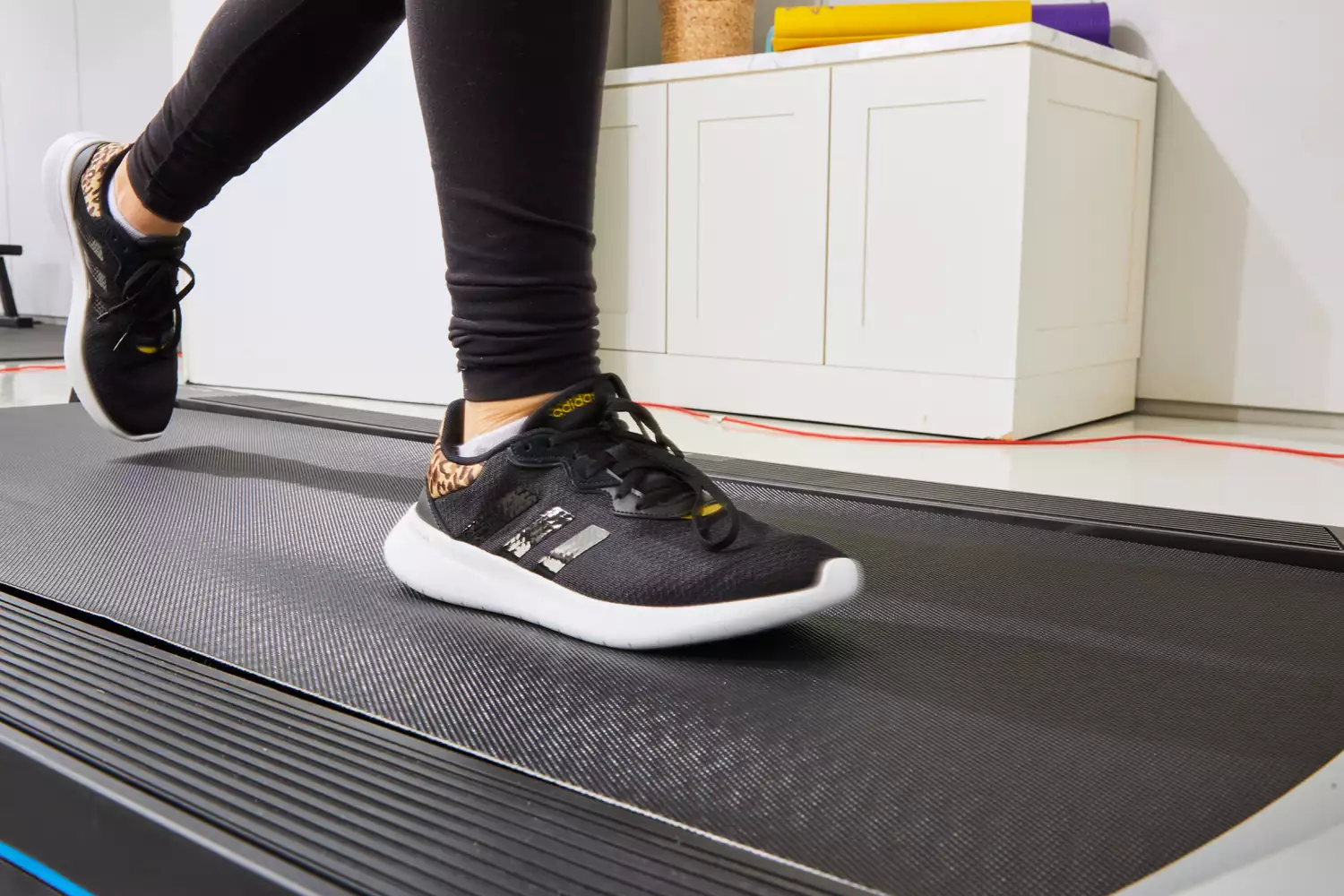Person wearing Adidas Women's Cloudfoam Qt Racer Running Shoes on a treadmill