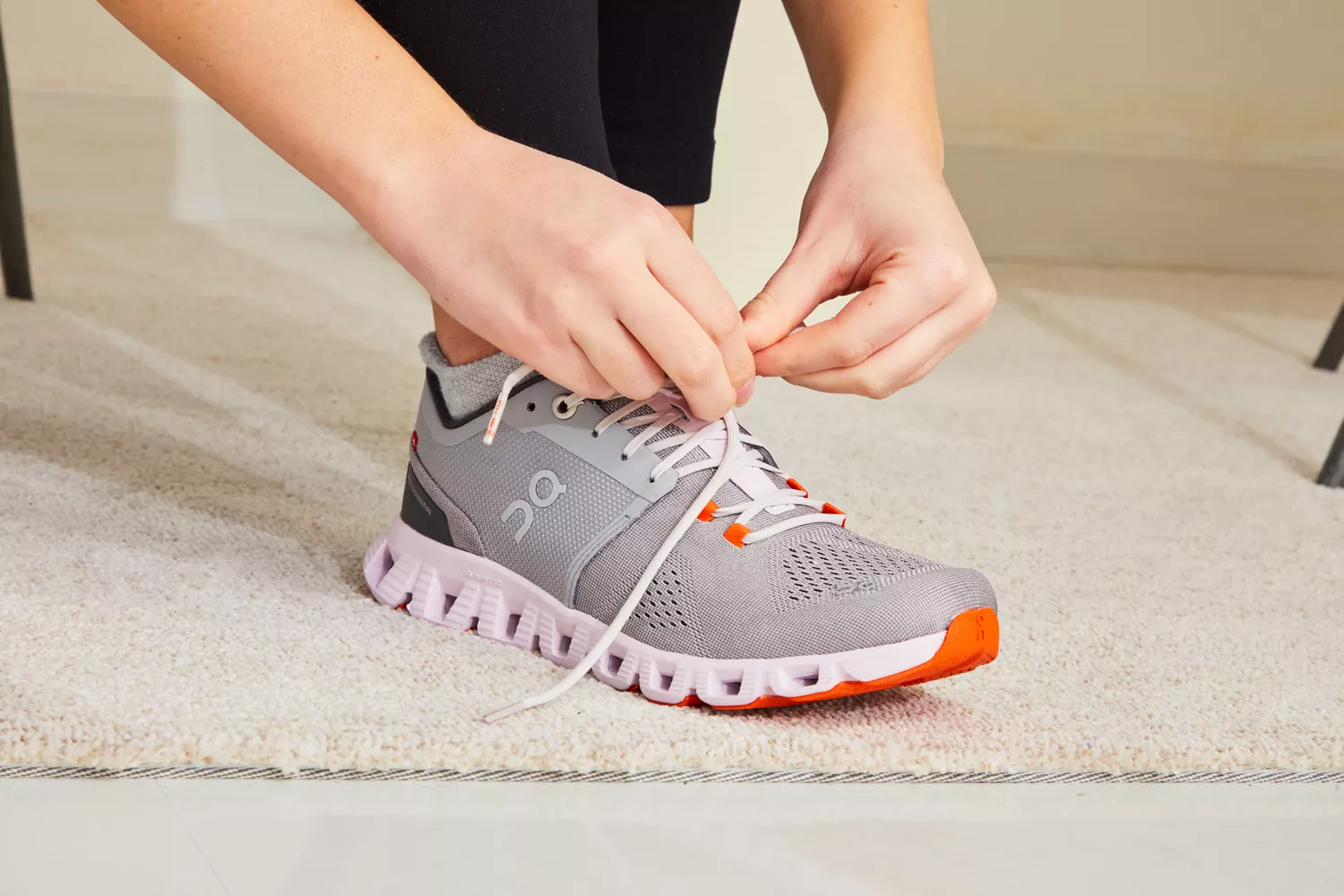 Person lacing up On Running Women's Cloud X Running Shoe