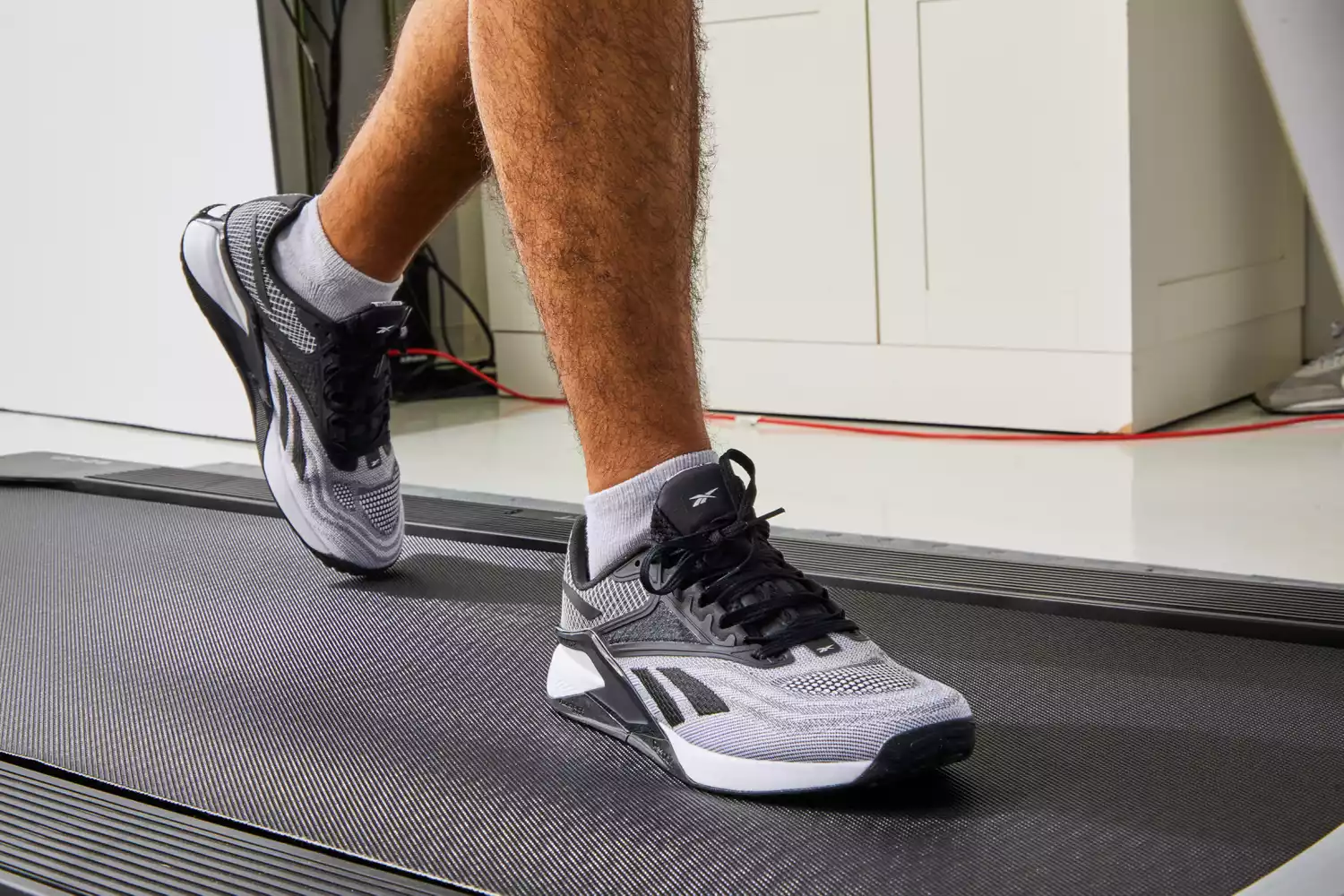 A person wearing Reebok Men's Nano X2 Cross Trainers while on a treadmill