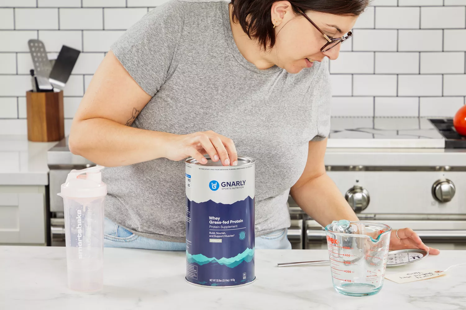 Person reading the lid of Gnarly Grass-Fed Whey Vanilla Protein Supplement