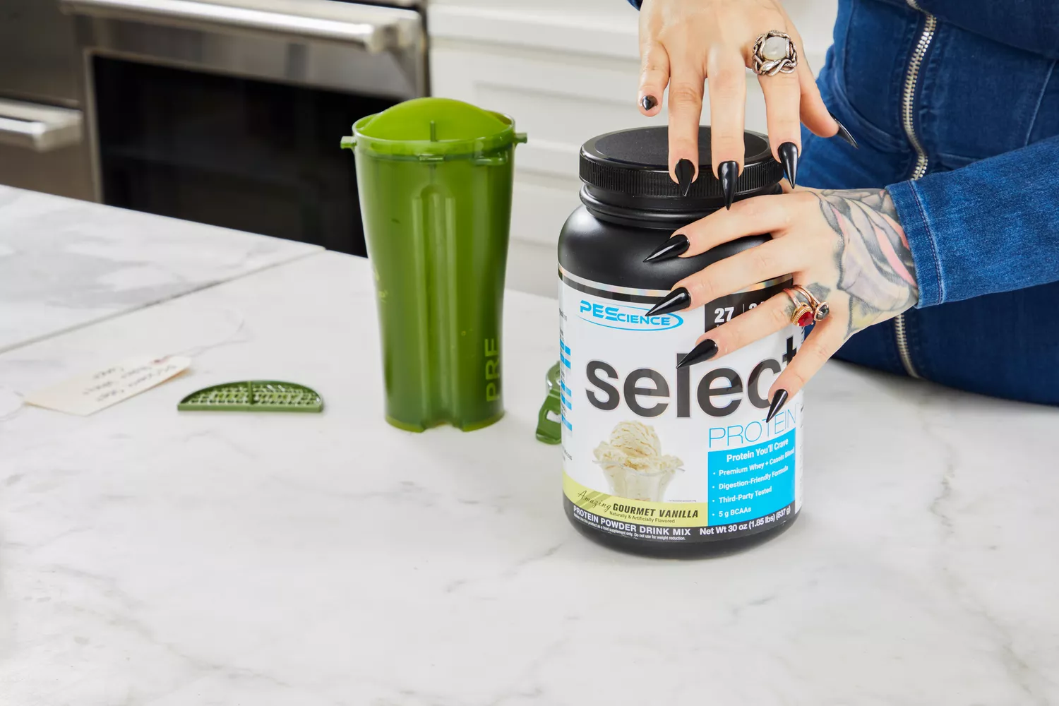 Two hands removing the lid from the PEScience Select Protein Premium Whey + Casein Blend jar