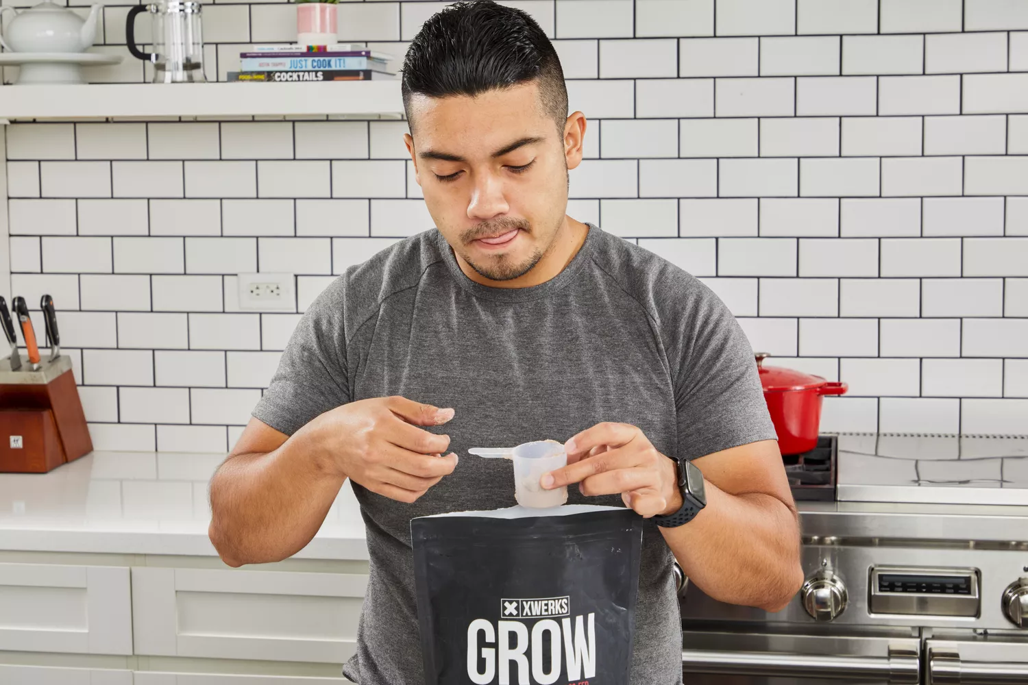 A person holding a scoop of Xwerks Grow 100% New Zealand Grass-Fed Whey Protein Isolate