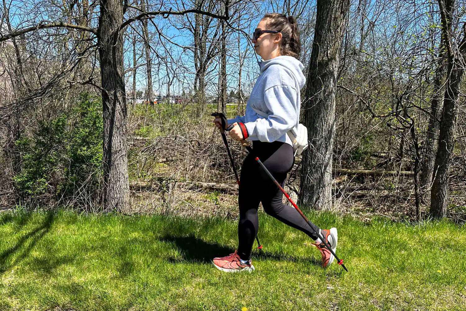 A side view of a person walking outside while using the Black Diamond Pursuit Carbon Z Poles