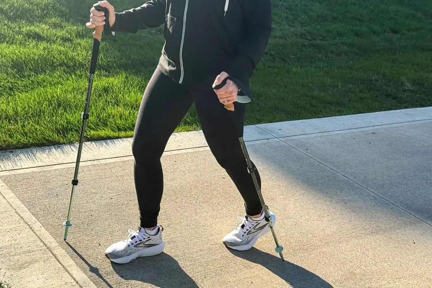 A person walks on concrete while using the Black Diamond Pursuit Trekking Poles