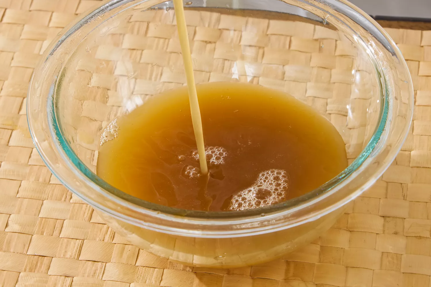 Kitchen Basics Turmeric &amp; Ginger With Lemongrass Chicken Bone Broth is poured into a glass bowl