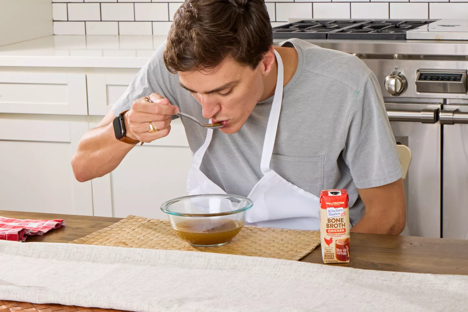 A person sips on Kitchen Basics Turmeric &amp; Ginger With Lemongrass Chicken Bone Broth