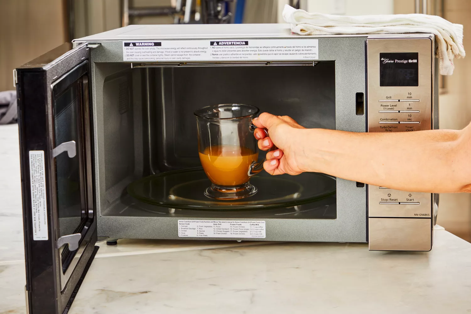 A glass of Pacific Foods Chicken Bone Broth is placed in a microwave