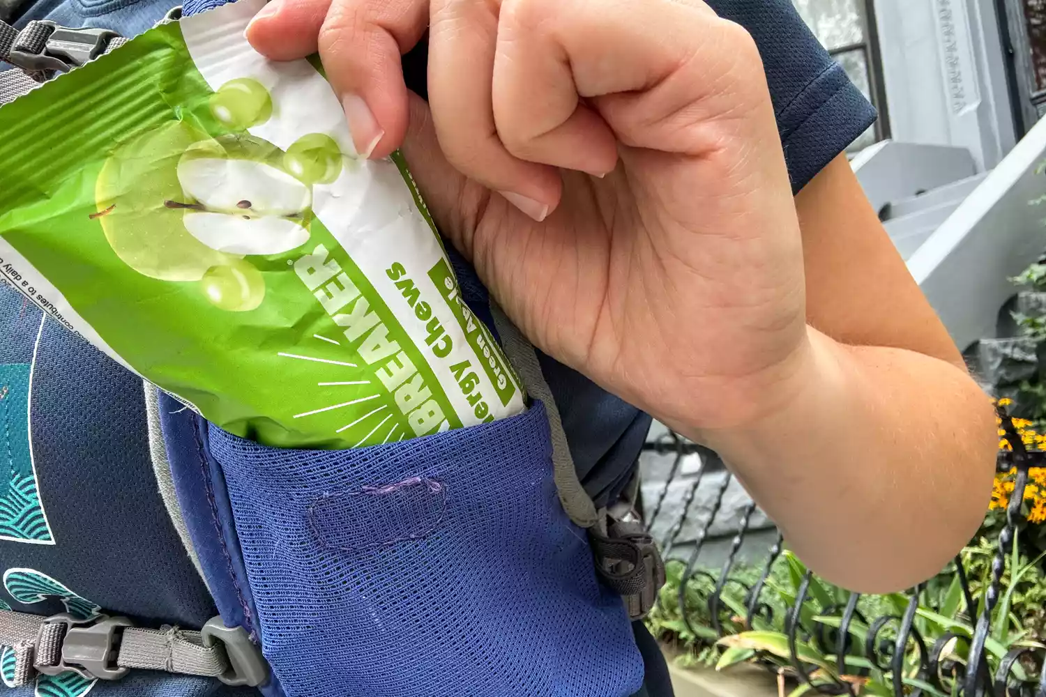 A person removes a packet of Bonk Breaker Strawberry Energy Chews from a pocket