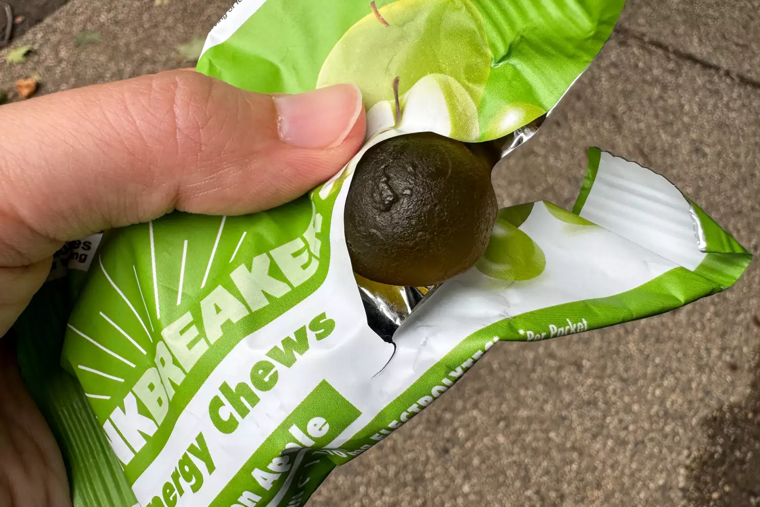 A person removes a Bonk Breaker Strawberry Energy Chew from the package