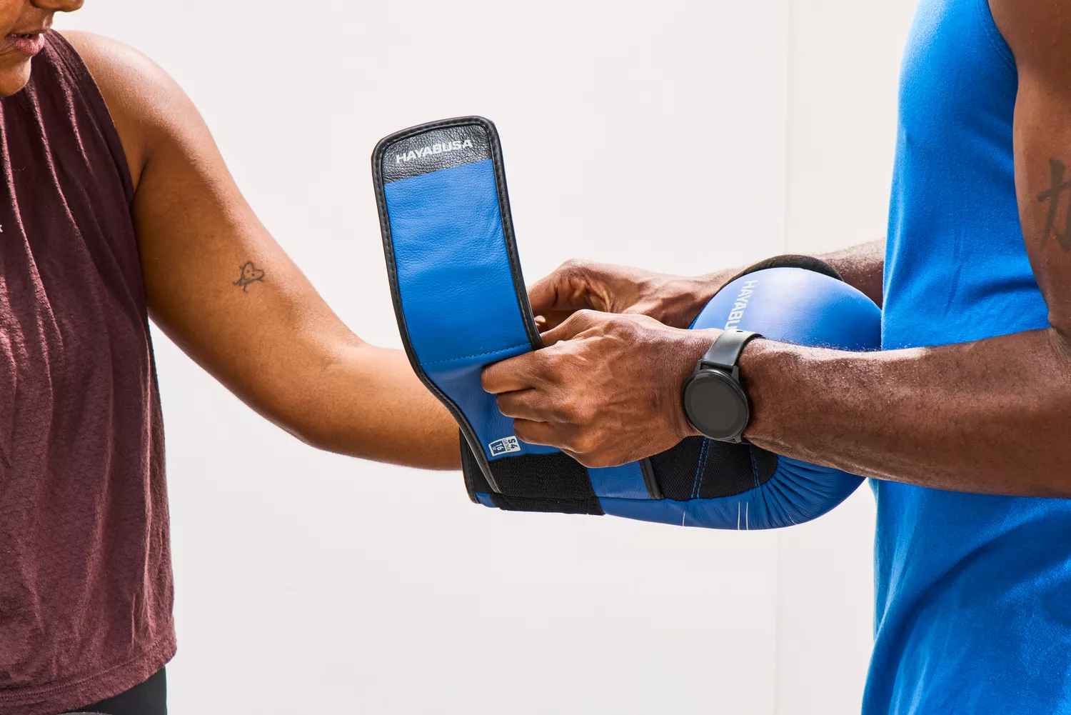 A person secures the Hayabusa S4 Leather Boxing Glove to a person's hand