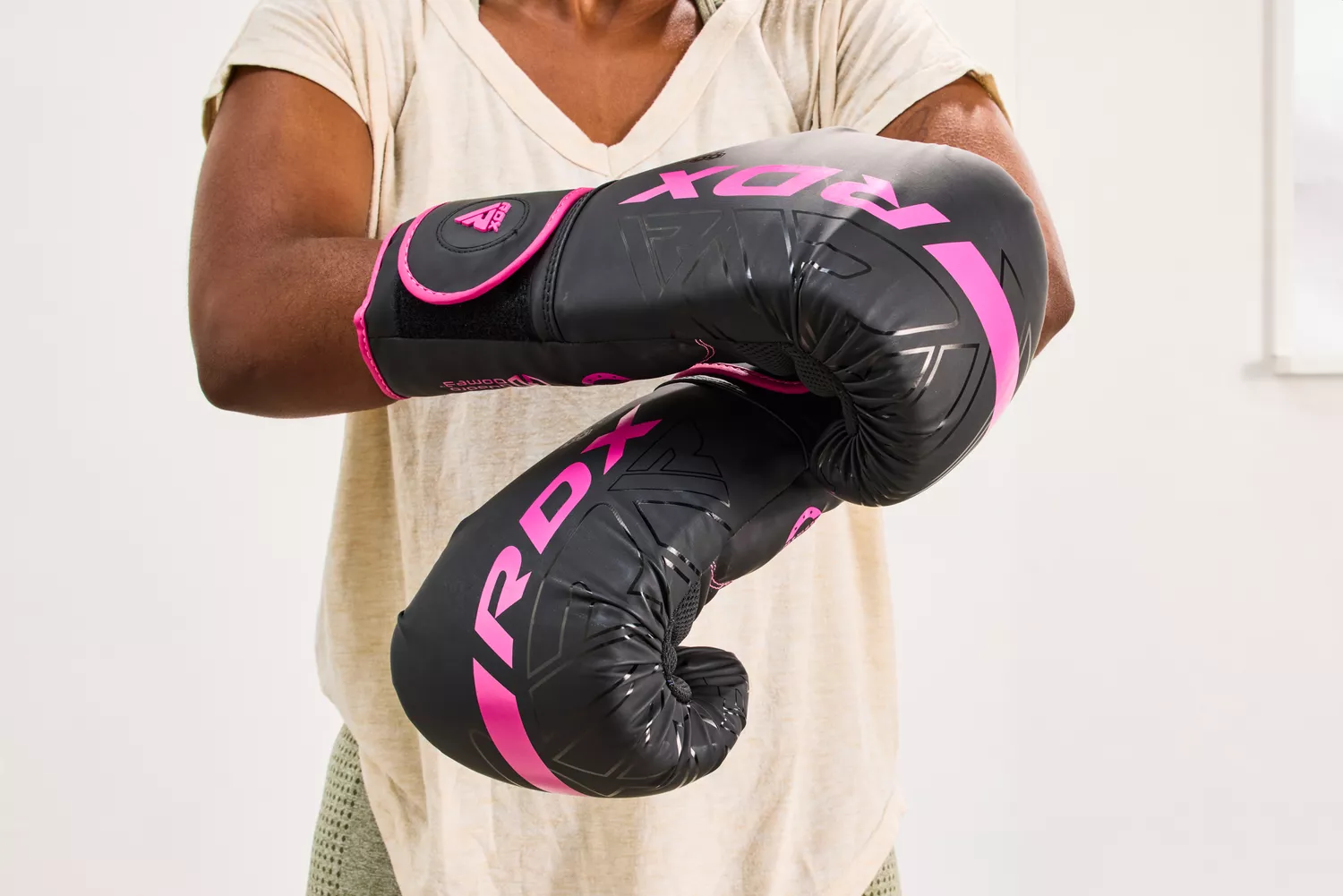 A person tightens the strap on the RDX Boxing Gloves