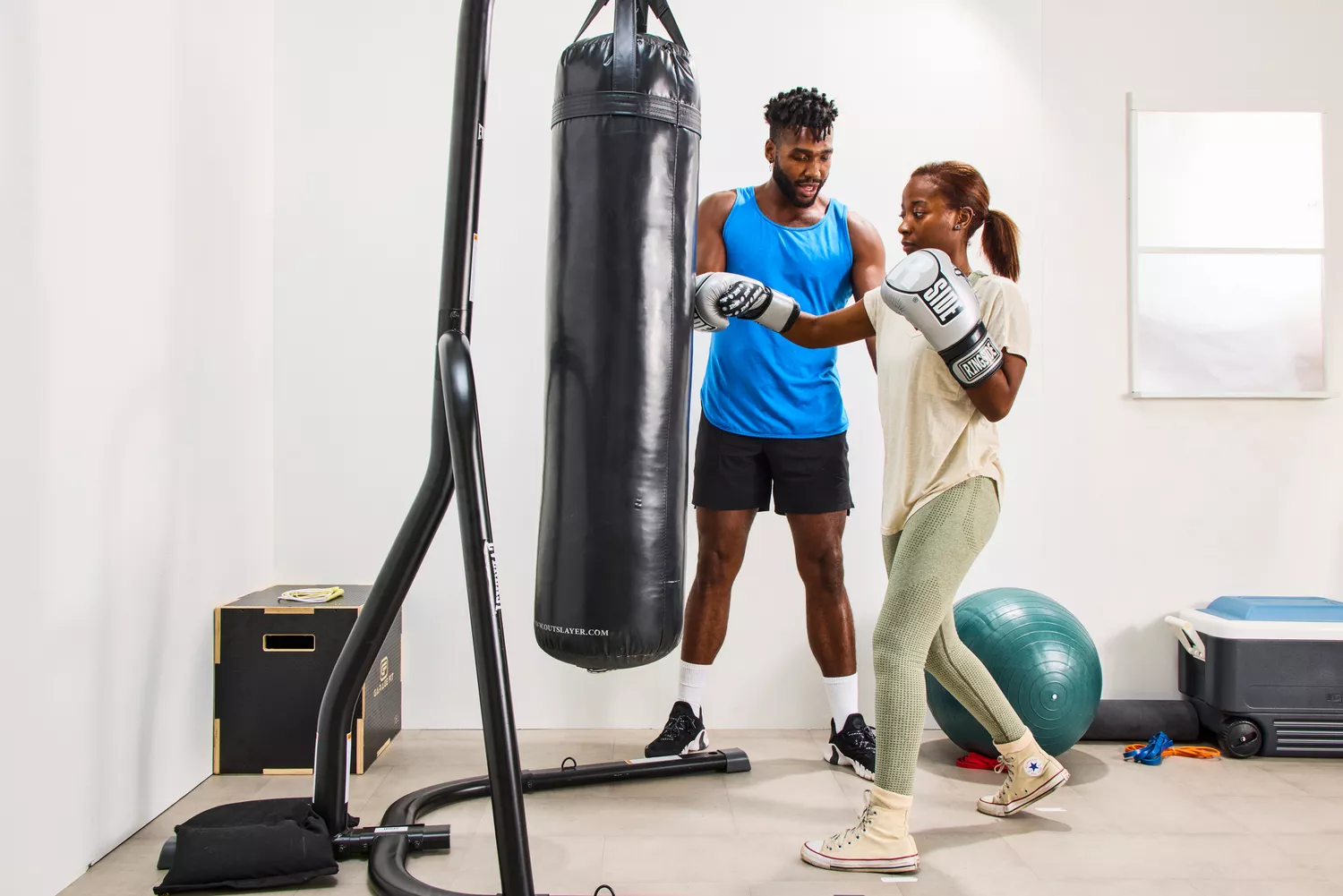 A person punches a bag while wearing the Ringside Apex Flash Sparring Gloves