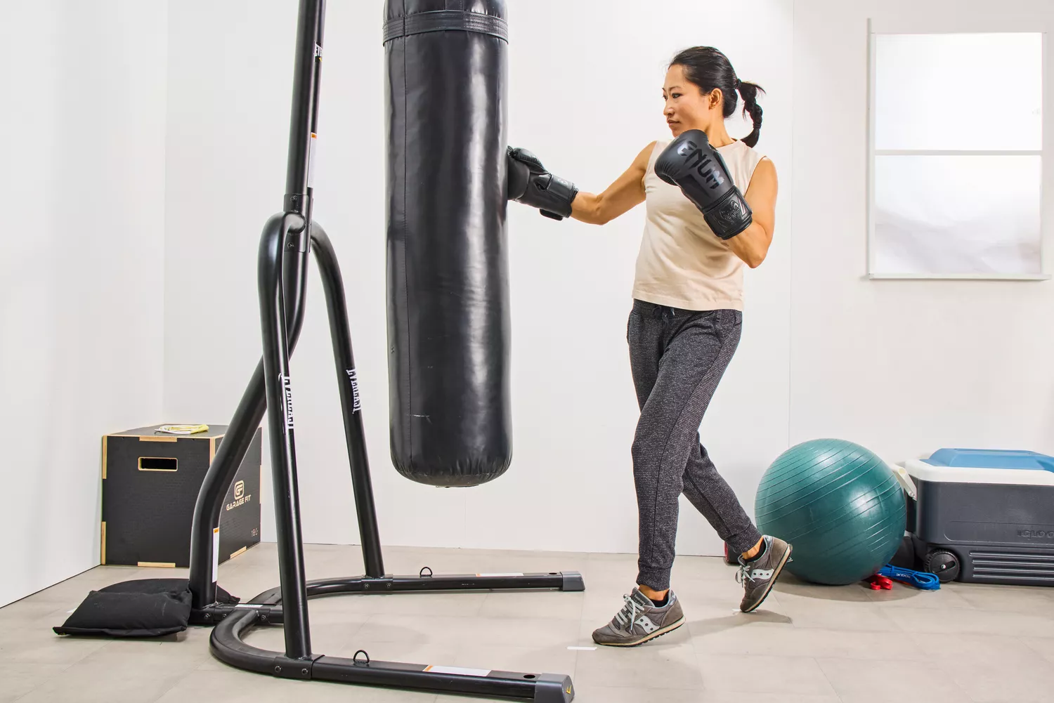 A person punches a bag while wearing the Venum Elite Boxing Gloves