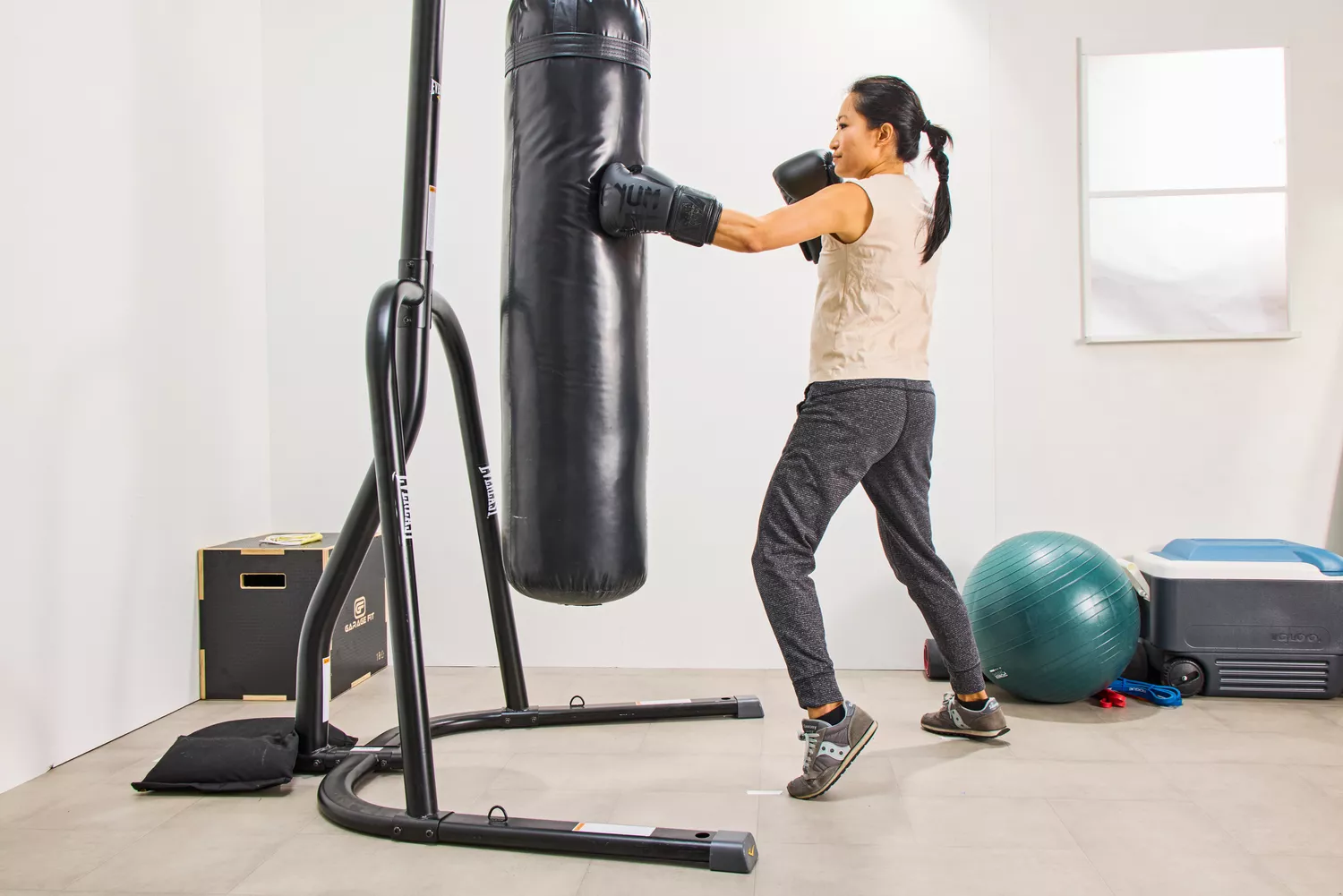 A person punches a bag while wearing the Venum Elite Boxing Gloves