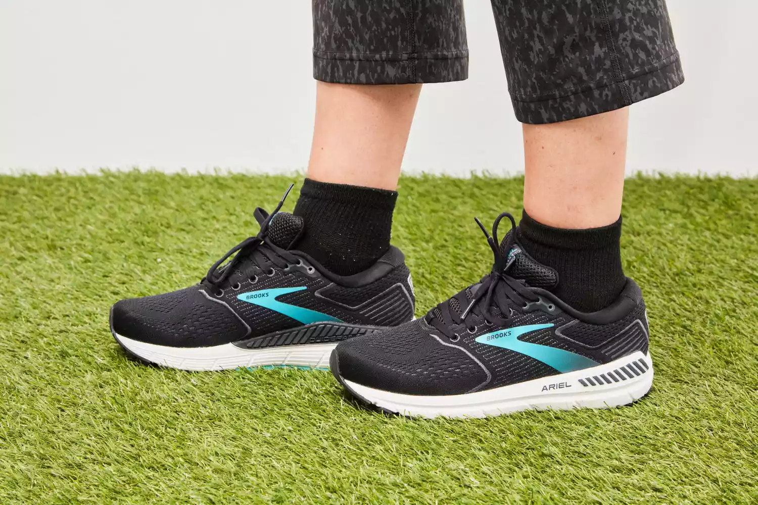 Person wearing Brooks Women’s Ariel '20 Running Shoes standing on grass