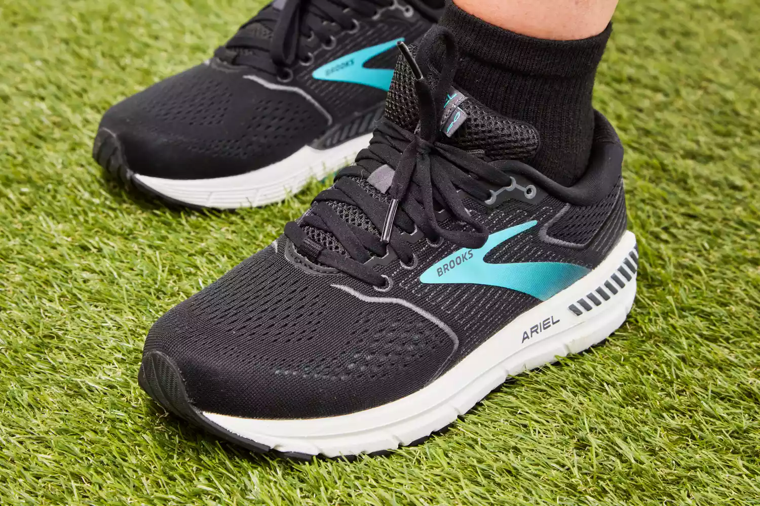 Person wearing Brooks Women’s Ariel '20 Running Shoes standing on grass