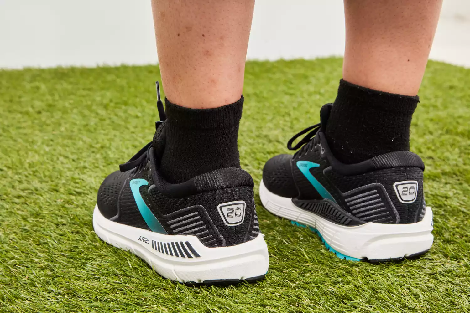 Person wearing Brooks Women’s Ariel '20 Running Shoes standing on grass