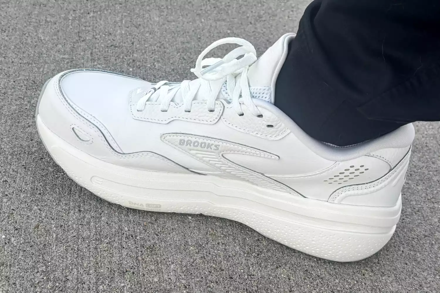 The Brooks Men's Ghost Max L Sneaker worn on carpet up close