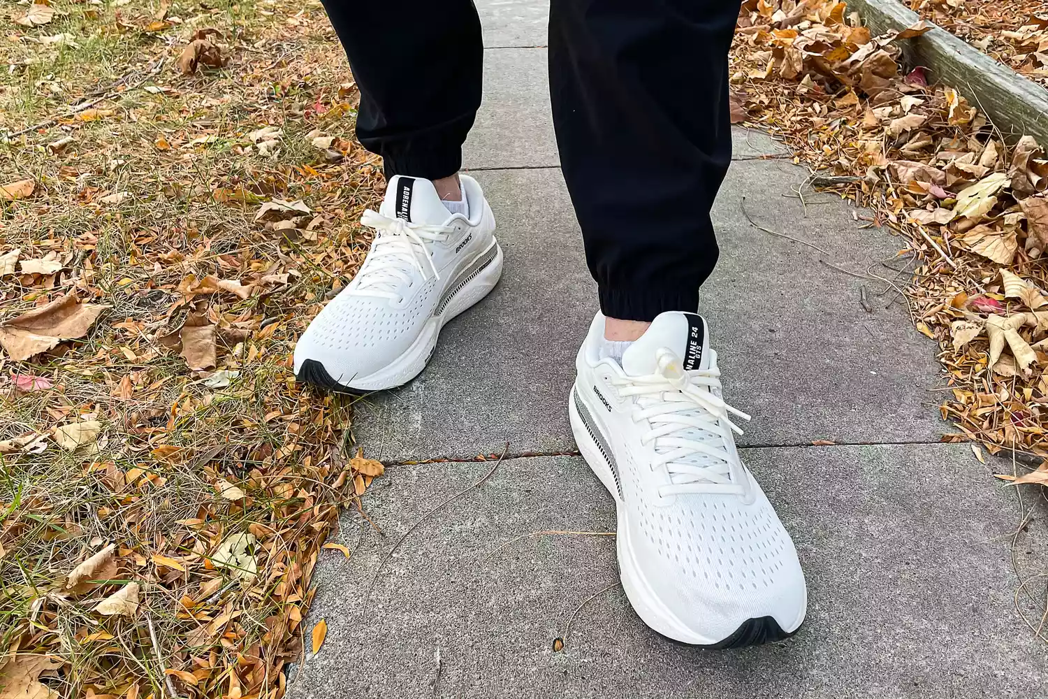 A person walks outside while wearing the Brooks Men's Adrenaline GTS 24 Running Shoes