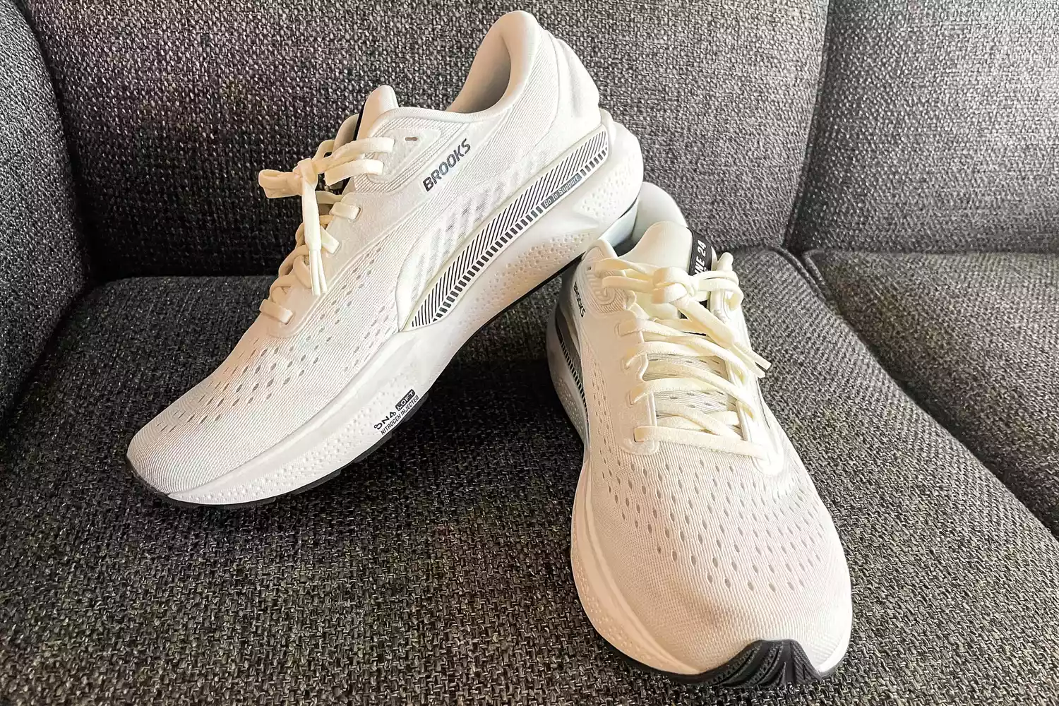 A pair of Brooks Men's Adrenaline GTS 24 Running Shoes on a couch