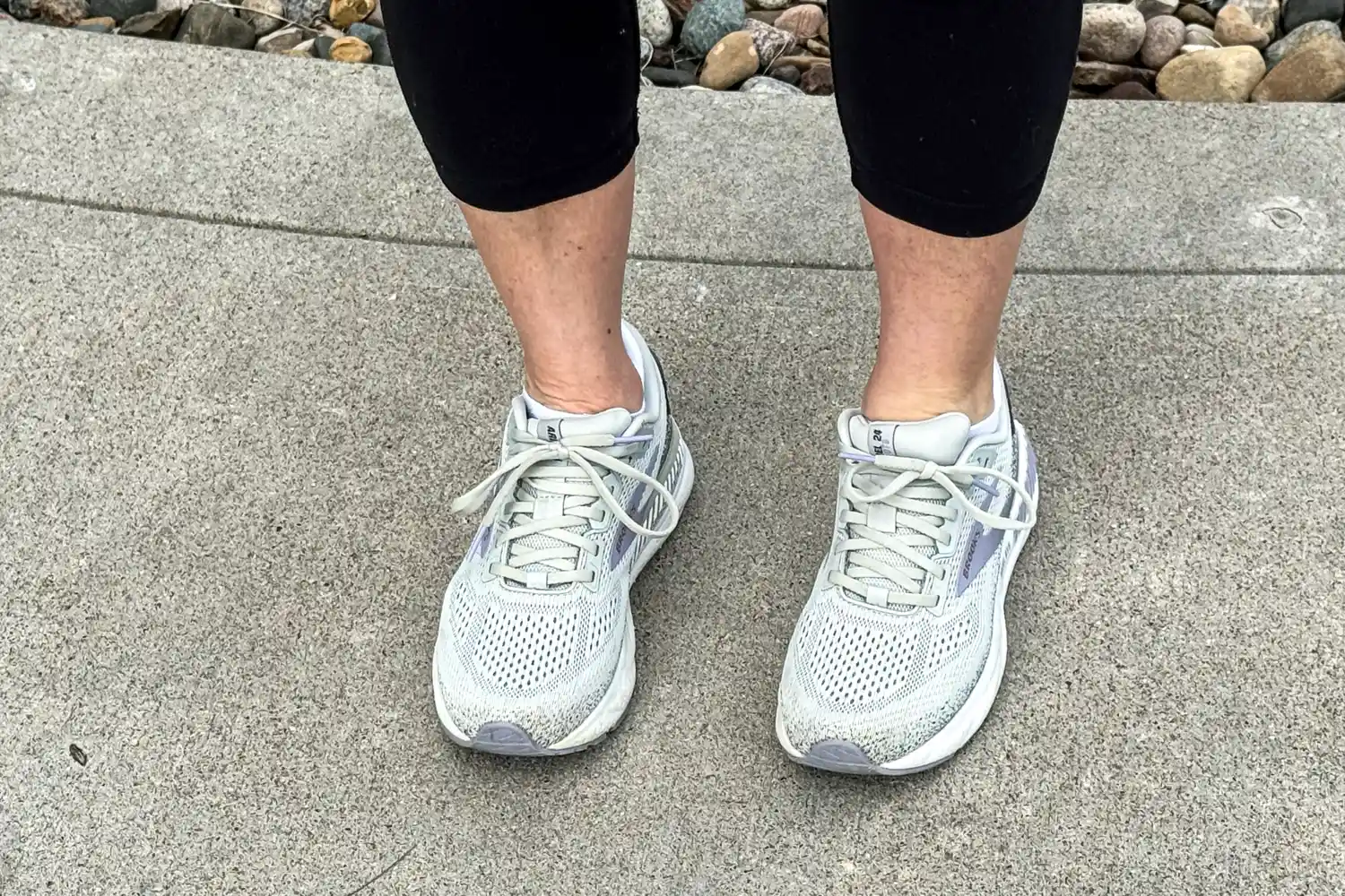 A person wears the Brooks Women's Ariel GTS 24 Running Shoes outside on concrete