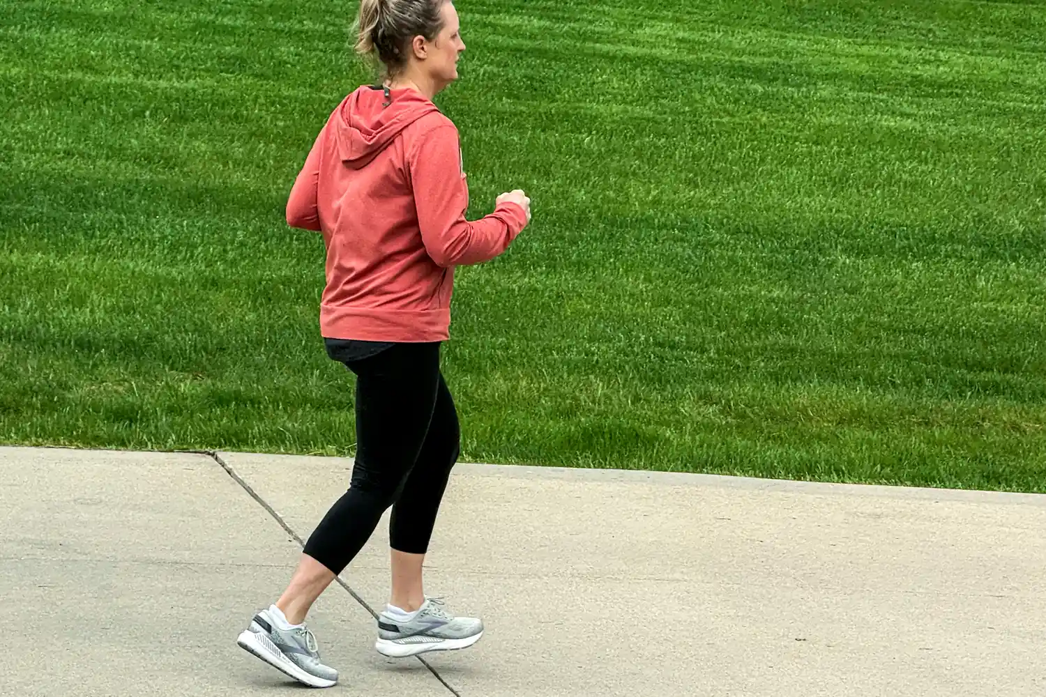 A person runs outside while wearing the Brooks Women's Ariel GTS 24 Running Shoes