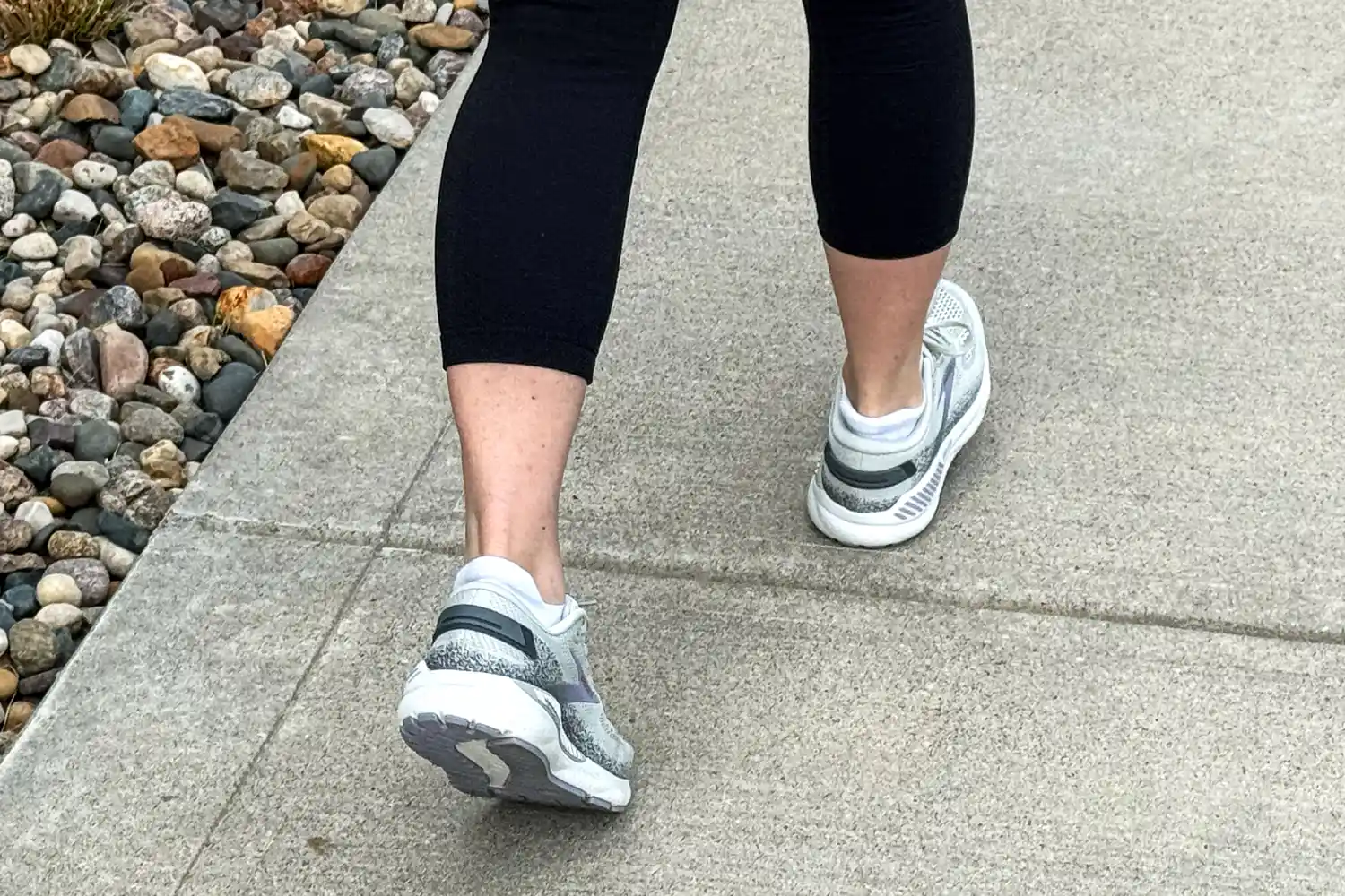 A person walks outside while wearing the Brooks Women's Ariel GTS 24 Running Shoes