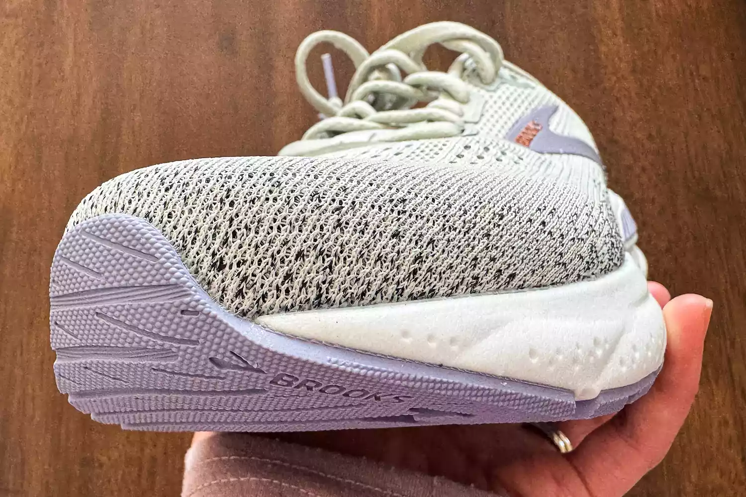 A person holds up the Brooks Women's Ariel GTS 24 Running Shoes