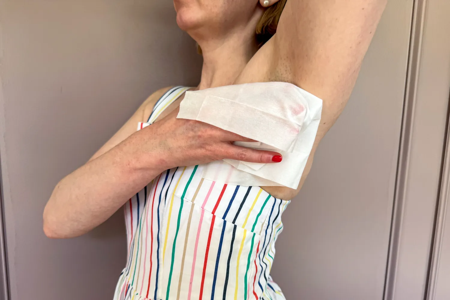 A person wipes their underarm with the Carpe On-the-Go Antiperspirant Underarm Wipe