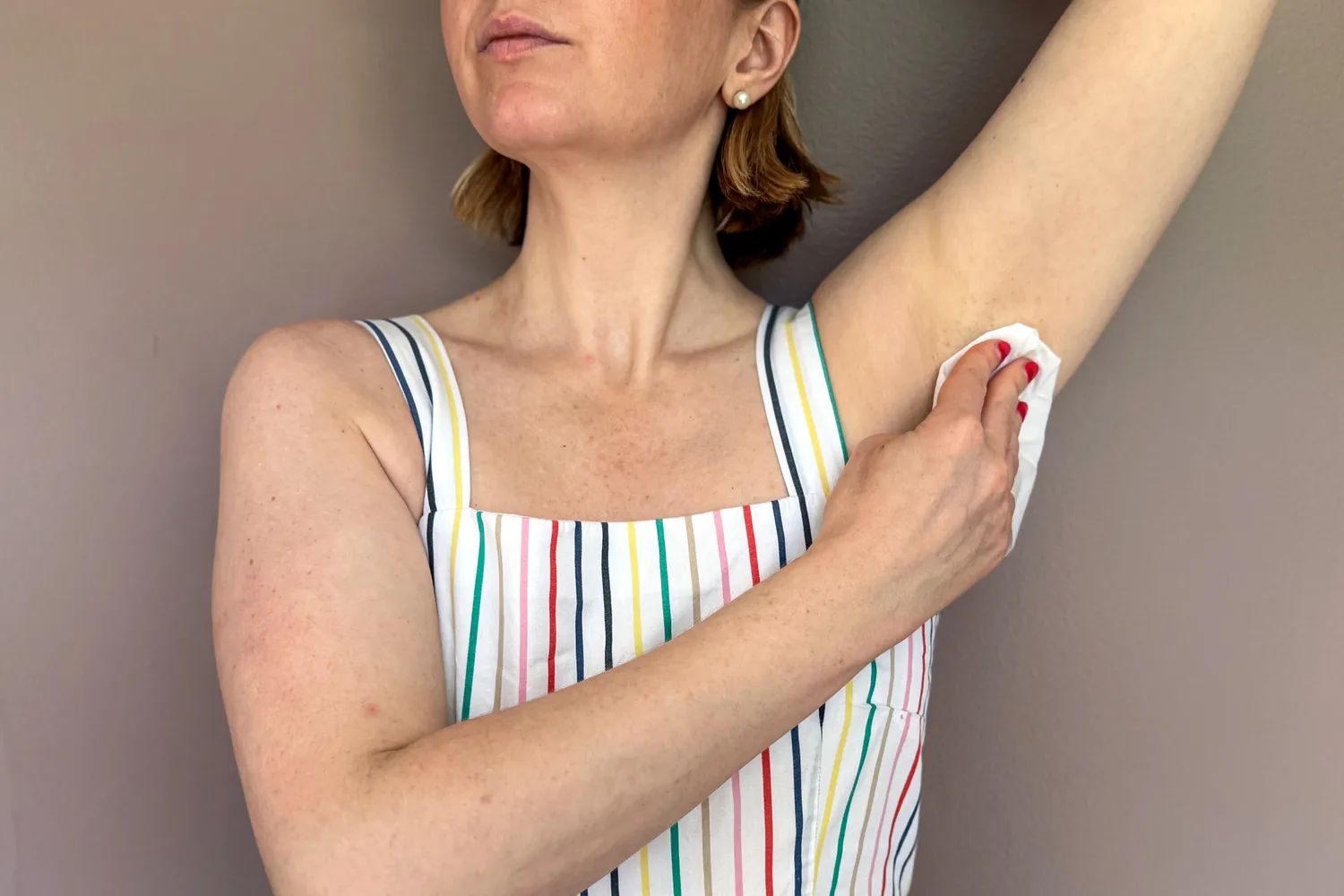 A person uses a Carpe On-the-Go Antiperspirant Underarm Wipe on their underarm