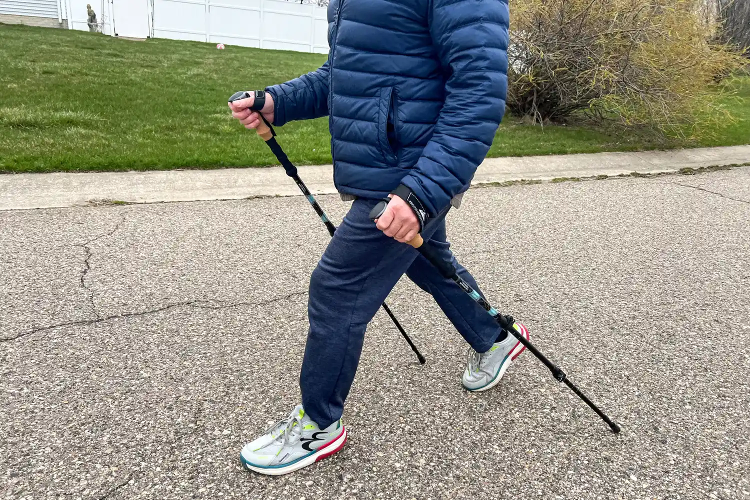 A person uses the Cascade Mountain Aluminum Quick Lock Trekking Poles with Cork Grip while walking