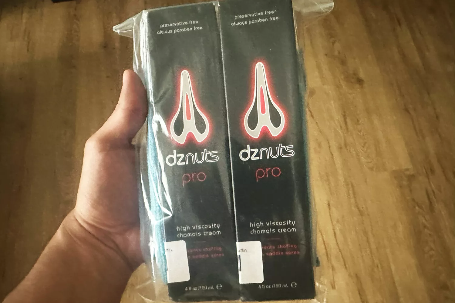 A person holds up two boxes of dznuts Men's Pro Chamois Cream