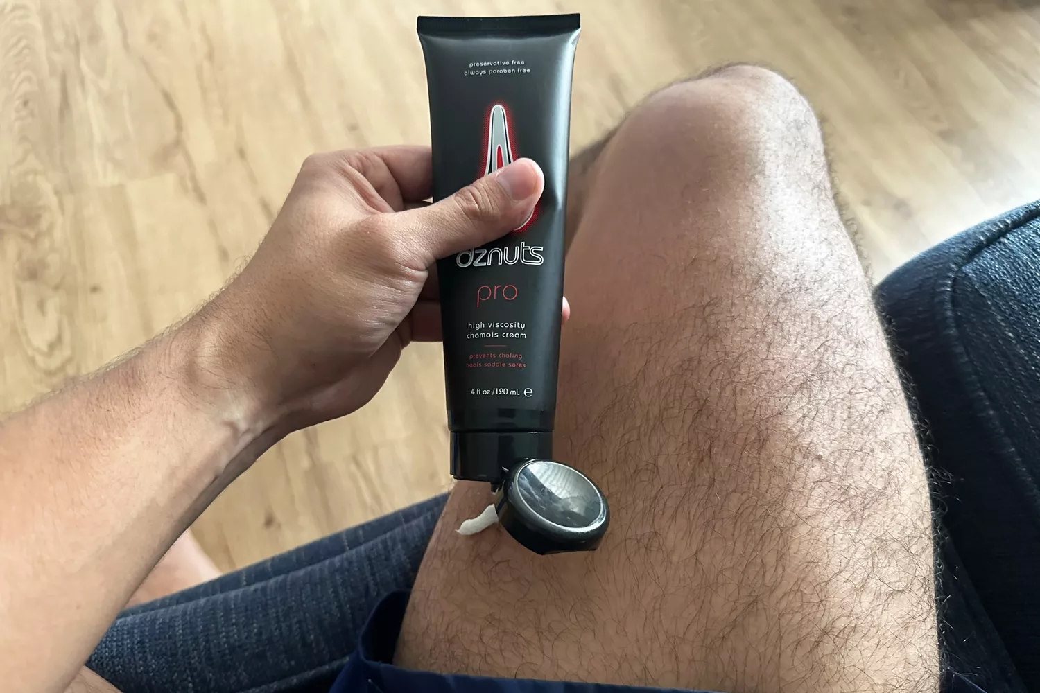 A person applies dznuts Men's Pro Chamois Cream to their leg