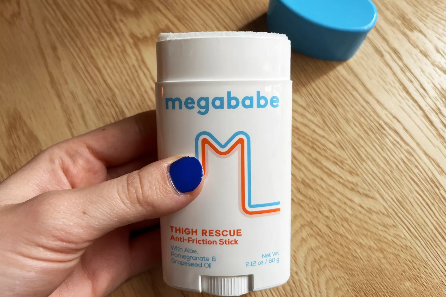 A person holds up a stick of Megababe Thigh Rescue