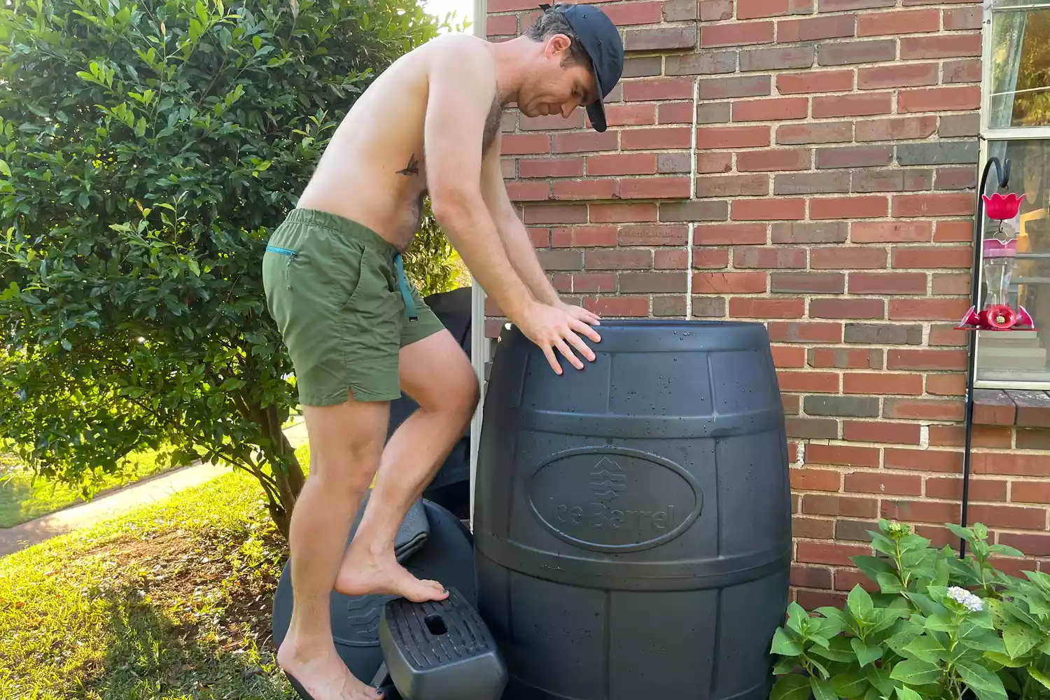 A person in a bathing suit getting into the Ice Barrel 400 Cold Therapy Training Tool