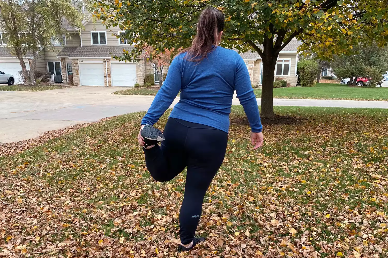 Person stretching outside while wearing Hoka Women's 28 Inch ColdSnap Run Tight