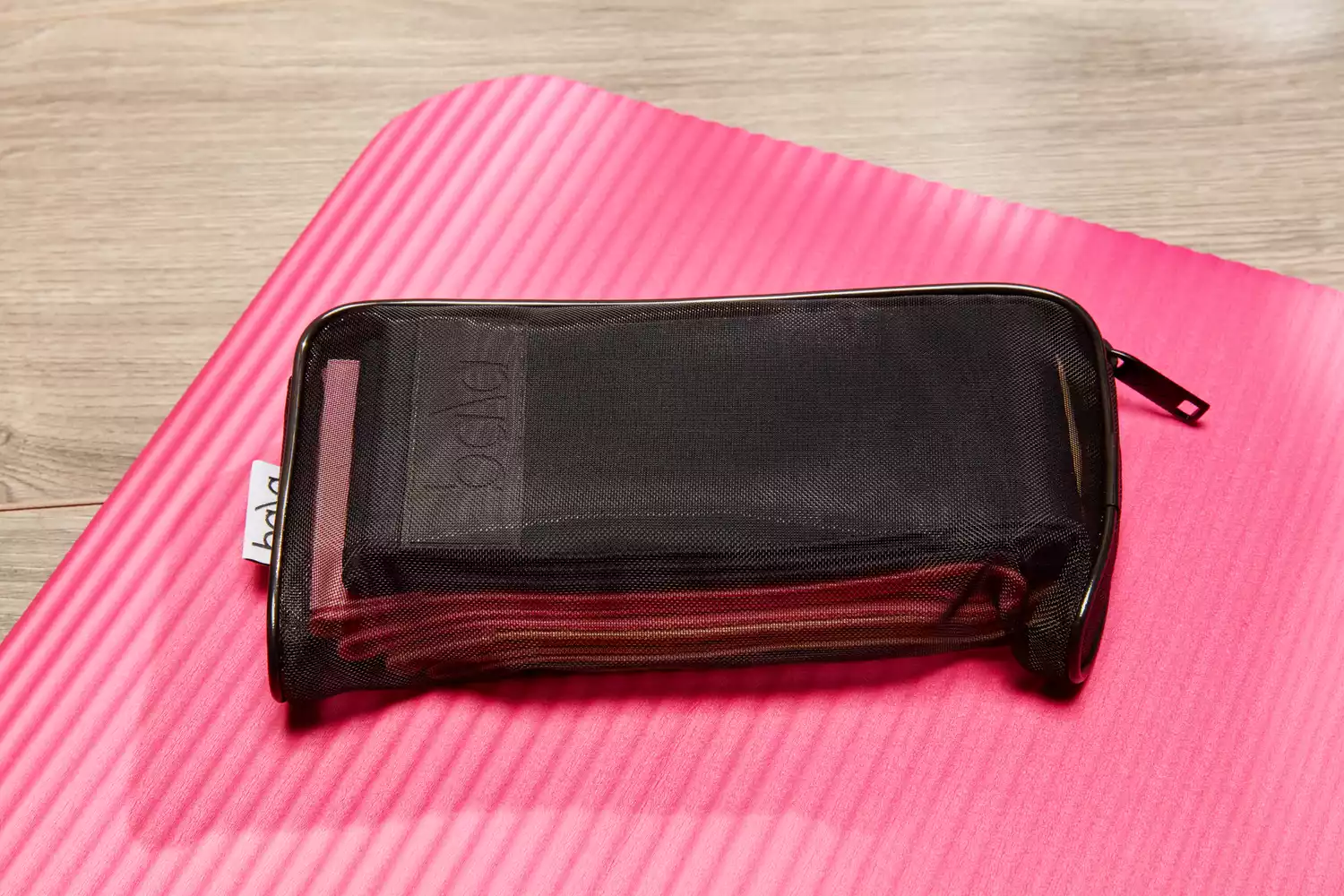 Bala Bands inside their mesh carrying case on a gym mat