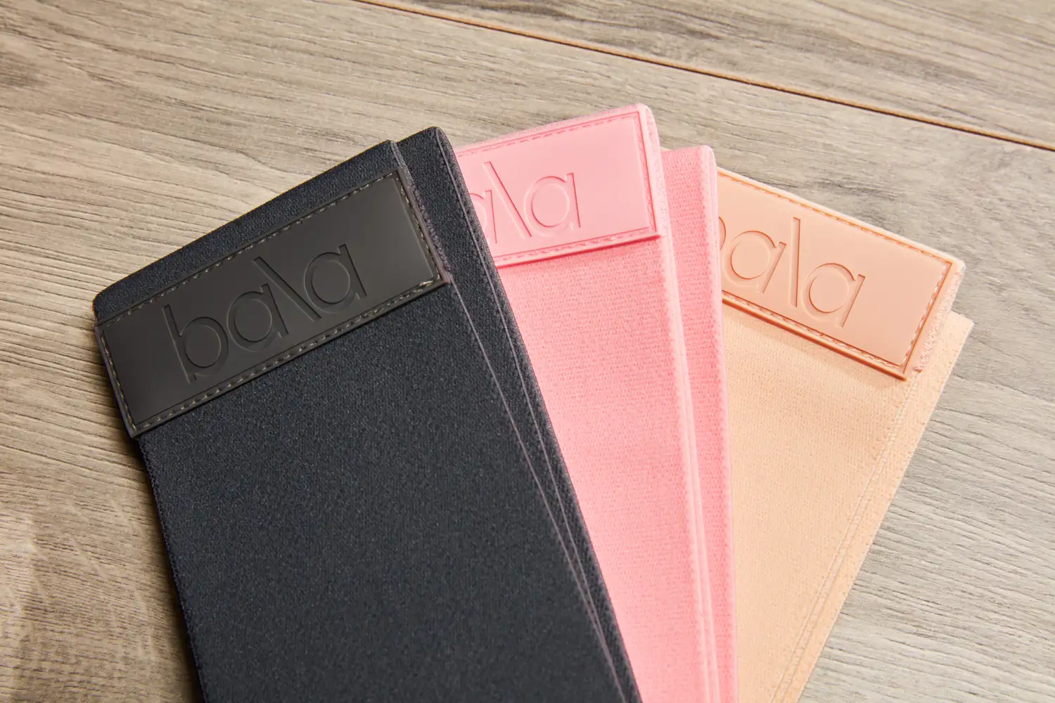 Three Bala Bands placed on a wooden surface showing their branding